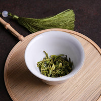 Anjibaicha Chinese green tea from Zhejiang, China, in infused loose-leaf with white porcelain gaiwan from Jingdezhen and green bamboo coaster